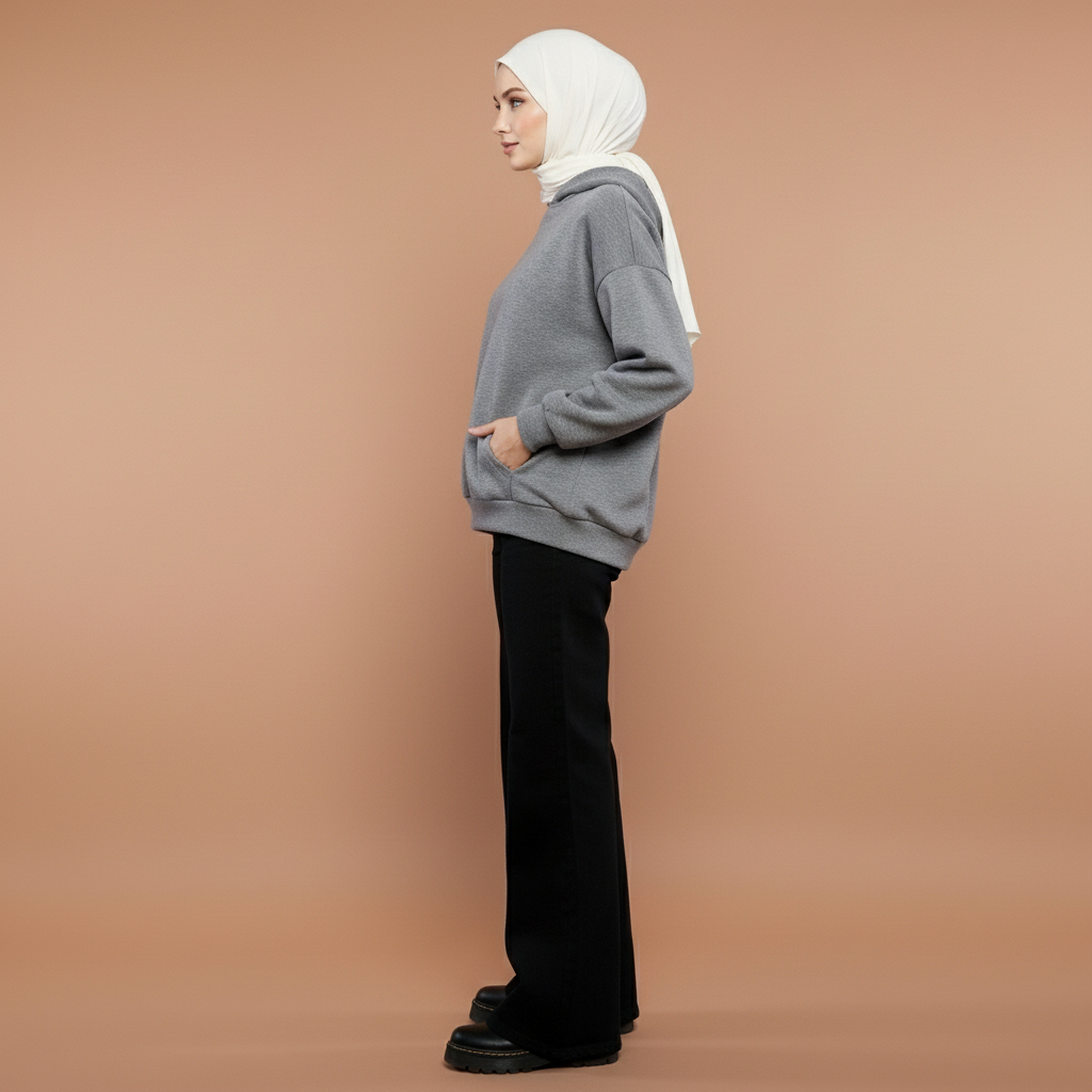 Low waist baggy jeans in black worn by a seated model facing front, showing a low-rise waistband, loose straight leg shape, relaxed drape through the thighs, full-length legs, and hem pooling naturally over footwear