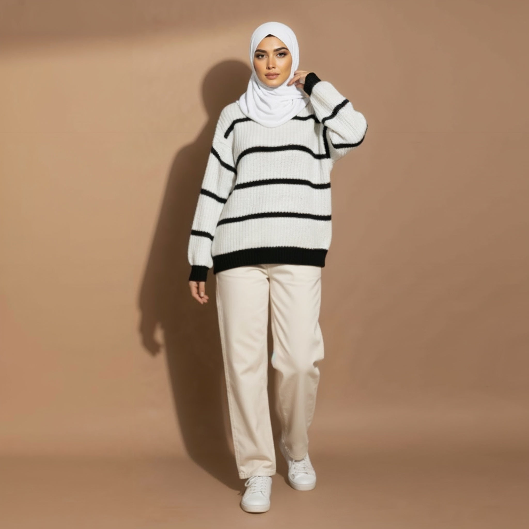 Chunky knit jumper oversized in white worn by a standing model in an upper-body view, showing horizontal black stripes and ribbed roll neckline